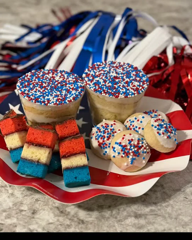 A Cookie Cartel celebration tray with layered cookies, sprinkled cookies, and two Dot Cakes.