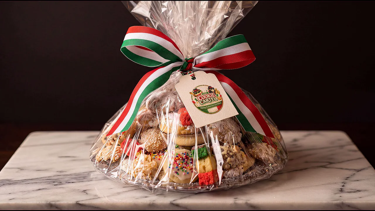 A Cookie Cartel cookie tray wrapped in cellophane with a tricolor bow and the Cartel seal.